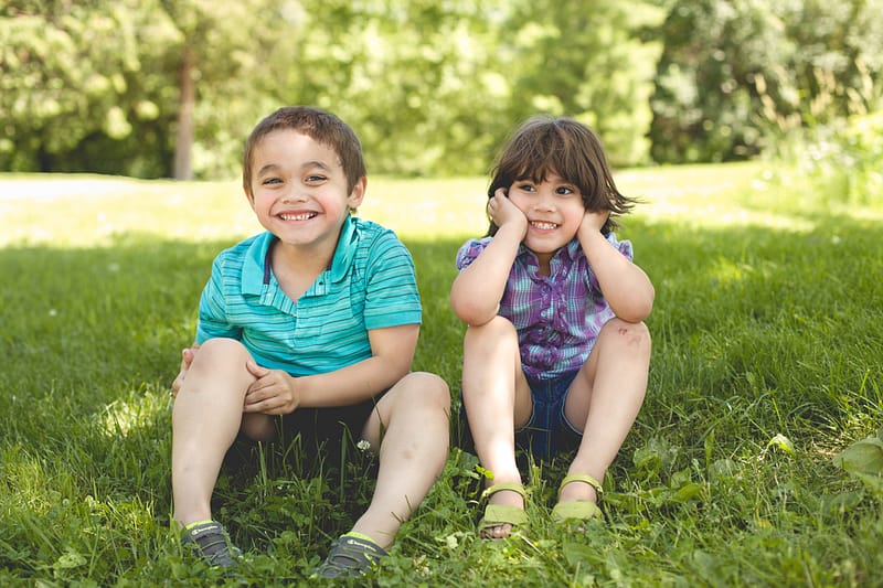kids sitting on grass laughing